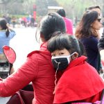 Jente med munnbind i den kinesiske byen Hangzhou.