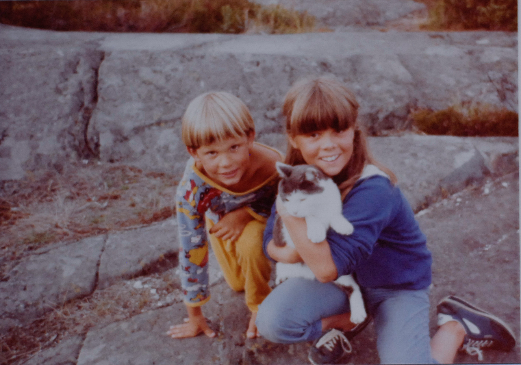 Torstein og Ellen Ugelstad som små på svaberg med katt.