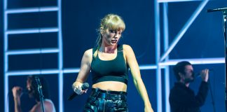 Taylor Swift dansar på ei scene med musikarar i bakgrunnen.