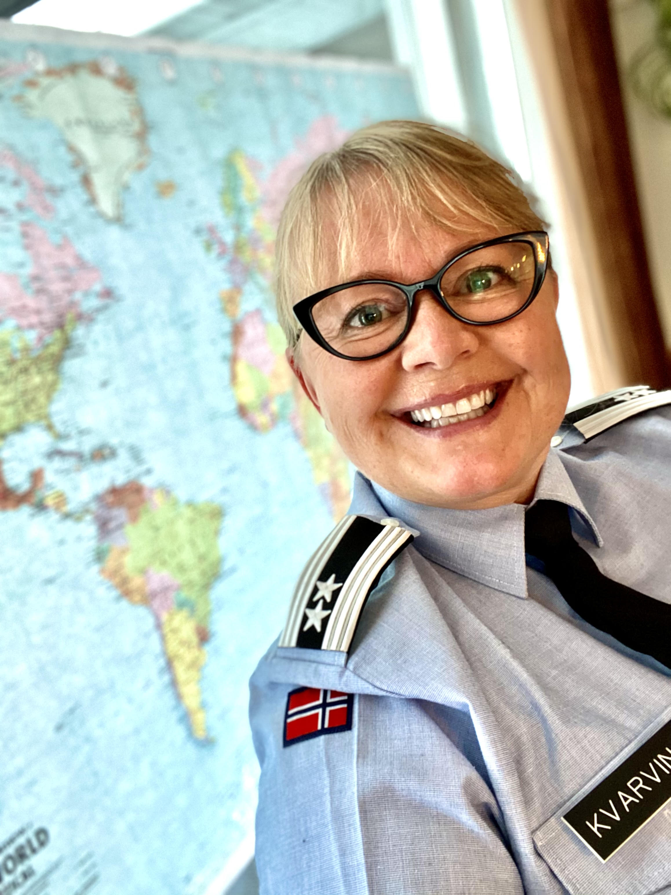 Oberstløytnant Lena Kvarving i uniformsskjorte og slips. Ho smiler stort til kamera.