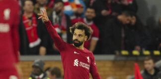 Salah løftar handa i vêret under kamp.