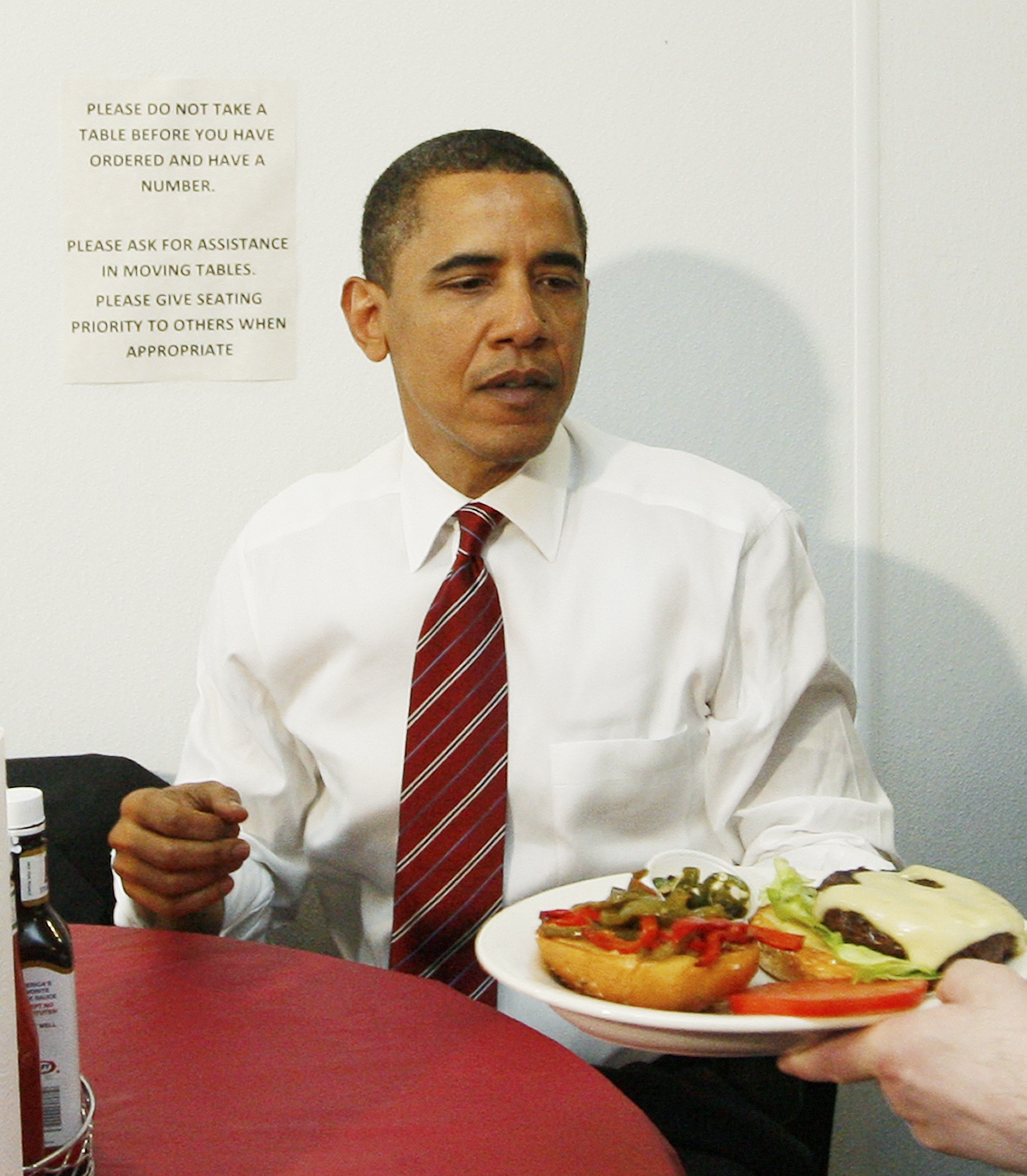 Obama får servert ein burgar på restaurant.