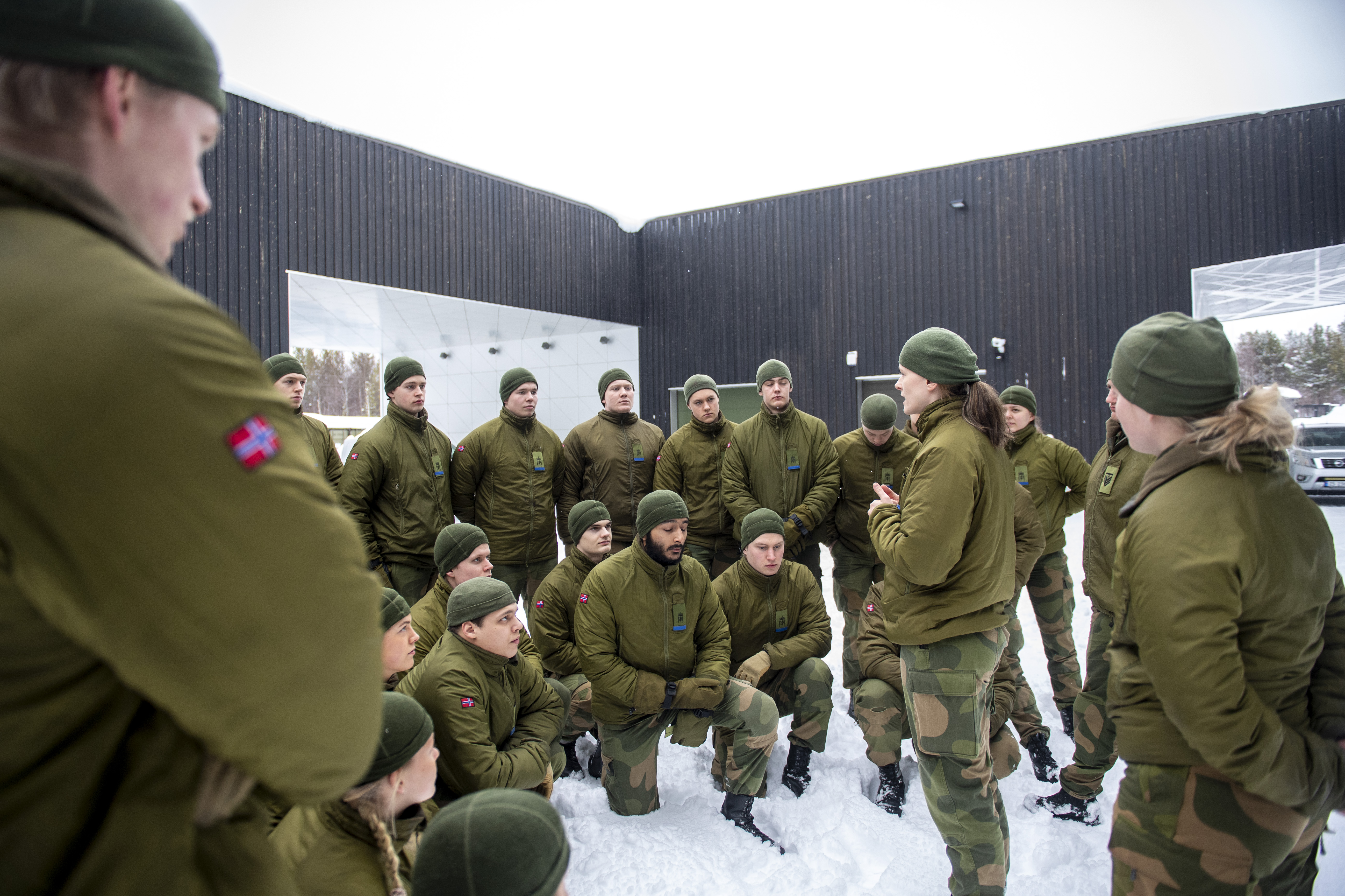 Vernepliktige har samling på Pasvik grensestasjon. Unge kledd i militære klede medan kvinneleg befal forklarar dei noko.