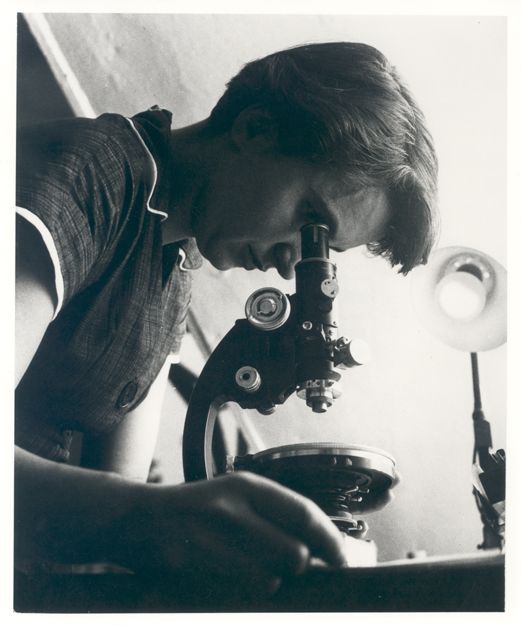 Kvinne ser i mikroskop
