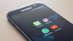 Samsung-telefon med appane til Snapchat, WhatsApp, Instagram og YouTube ligg på eit bord.
