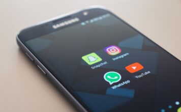 Samsung-telefon med appane til Snapchat, WhatsApp, Instagram og YouTube ligg på eit bord.