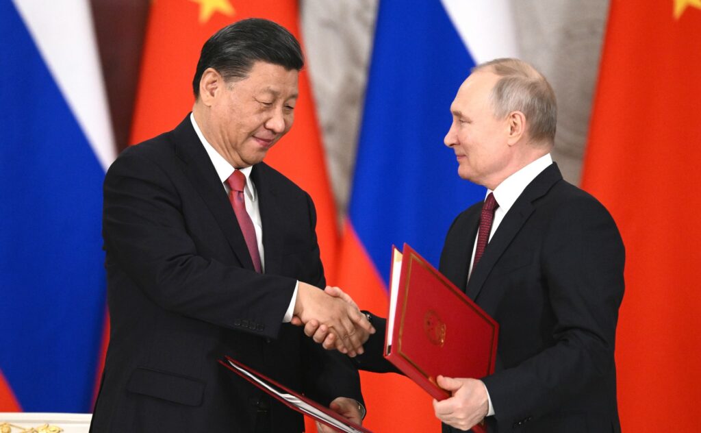 Xi Jinping og Vladimir Putin tek kvarandre i handa.