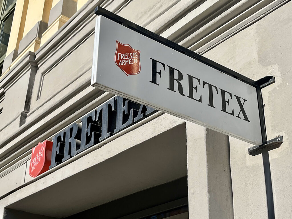Skilt av Fretex framfor ein butikk