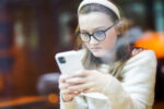 Jente i ungdomsalder ser på telefonen sin