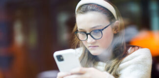 Jente i ungdomsalder ser på telefonen sin