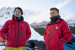 To menn i turklede i snødekt landskap