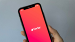 Hand som held ein telefon med Tinder-appen