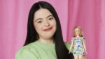 Jente med Downs syndrom held ei Barbie-dukke med Downs syndrom