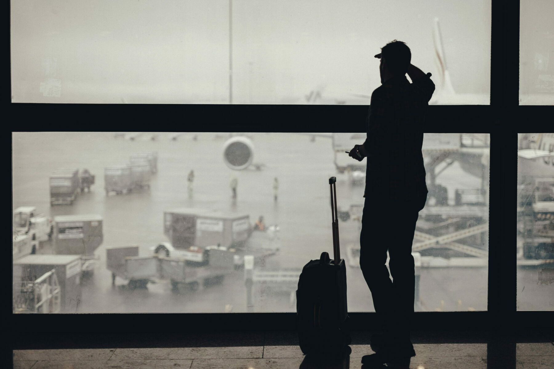 Vaksen mann ser gjennom vindauget på ein flyplass