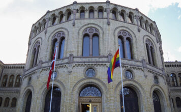 Regnbogeflagget og det norske flagget framfor Stortinget.