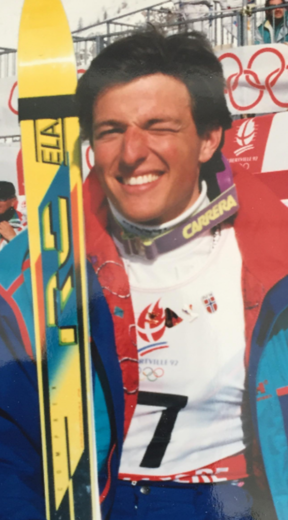 Ung mann i skidress med ski