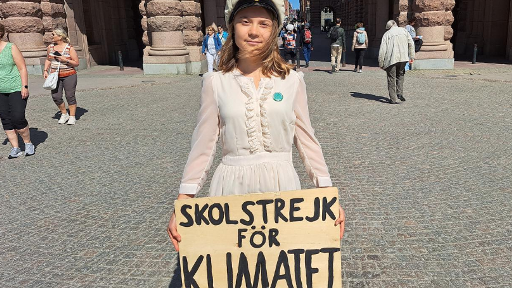 Ung kvinne holder skilt med teksten "skolstrejk for klimatet".