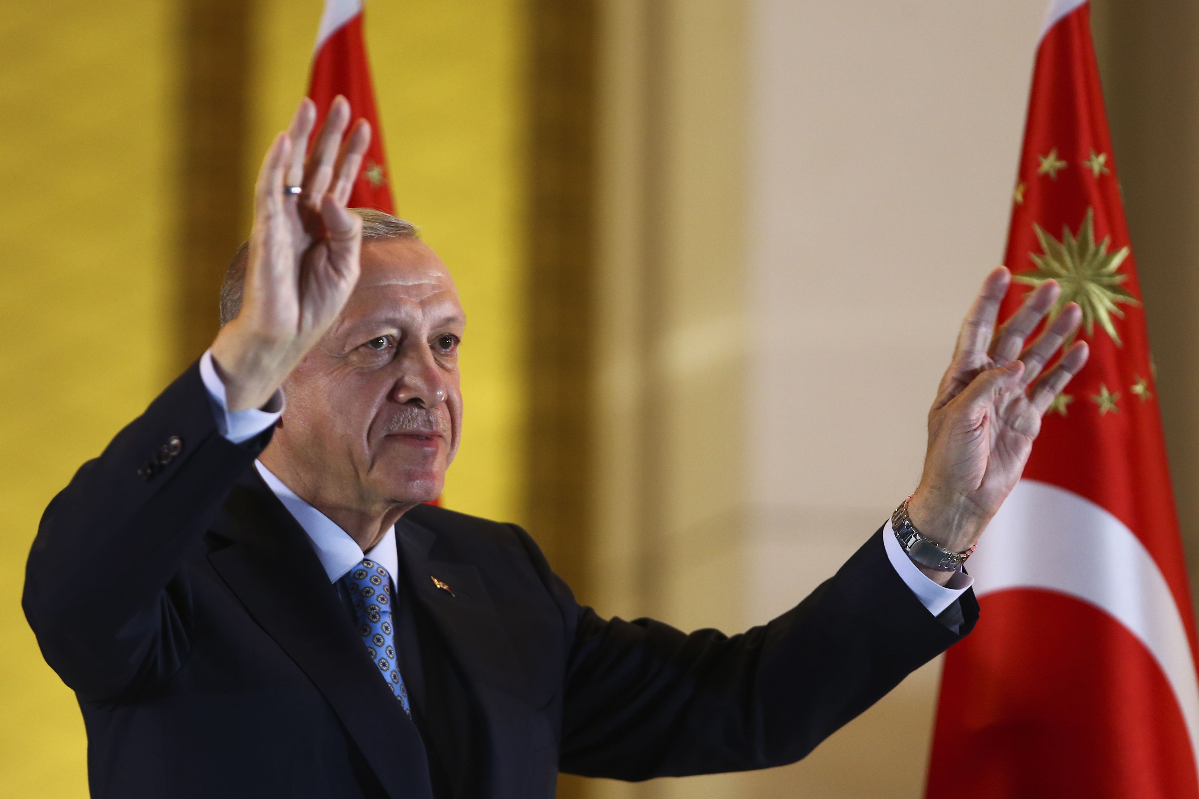 Erdogan vinker med tyrkisk flagg i bakgrunnen.