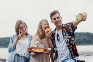 Tre ungdommar et pizzaog tek bilete