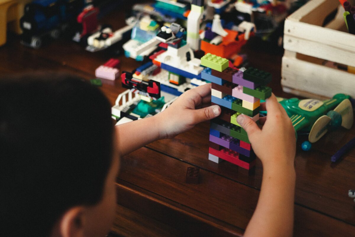 Barn byggjer med legoklossar.