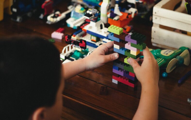 Barn byggjer med legoklossar.