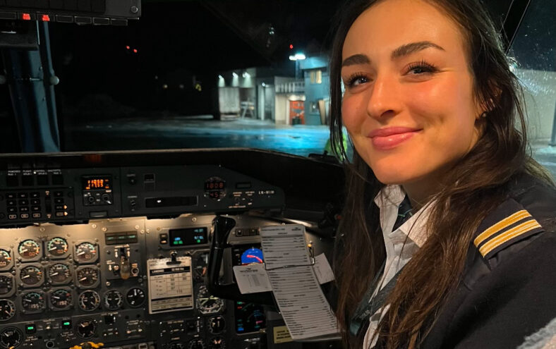 Kvinne som sitt i cockpit i eit fly.