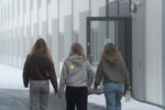 Tre jenter som går mot eit hus.