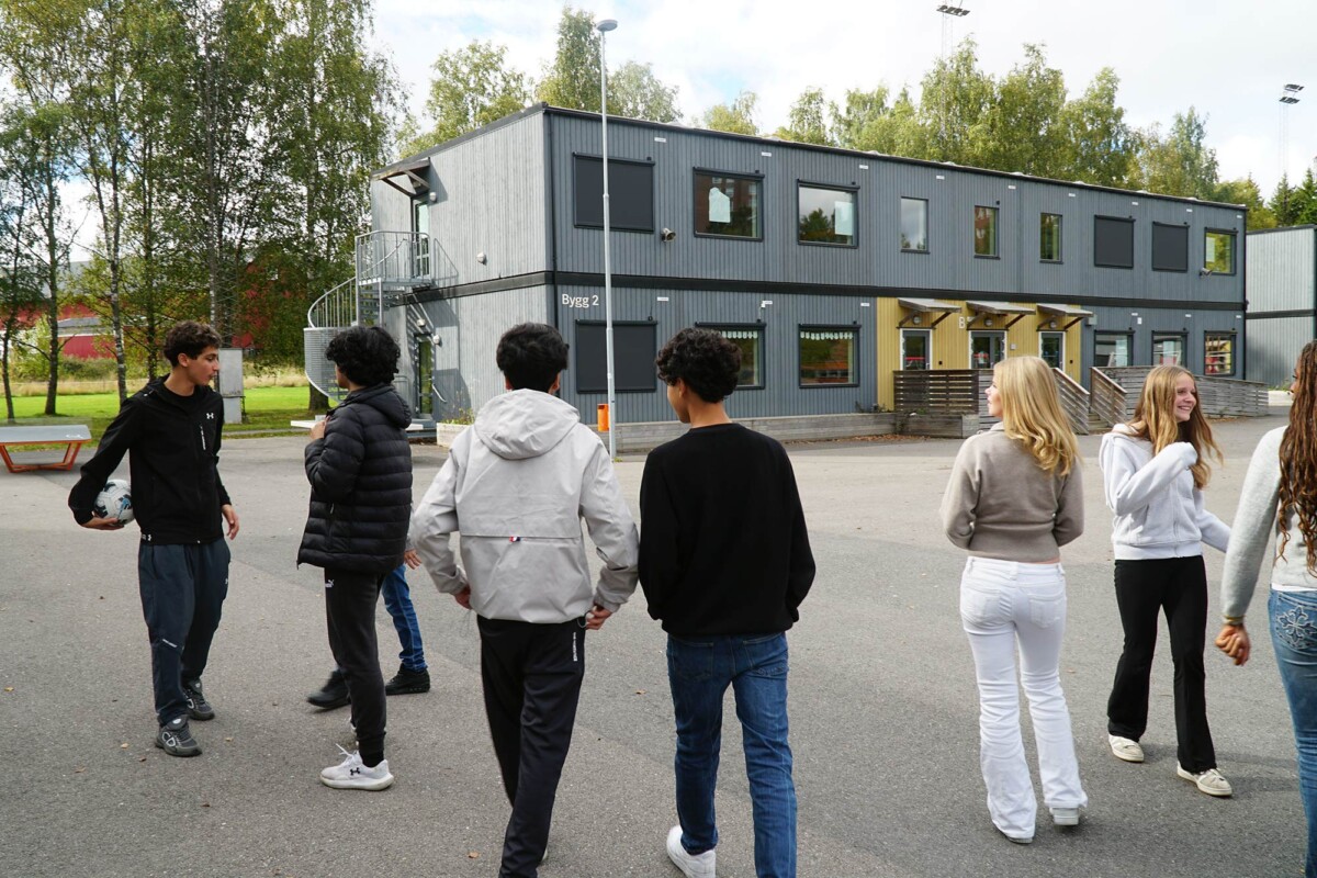 Åtte elevar går ut i ein skulegard.