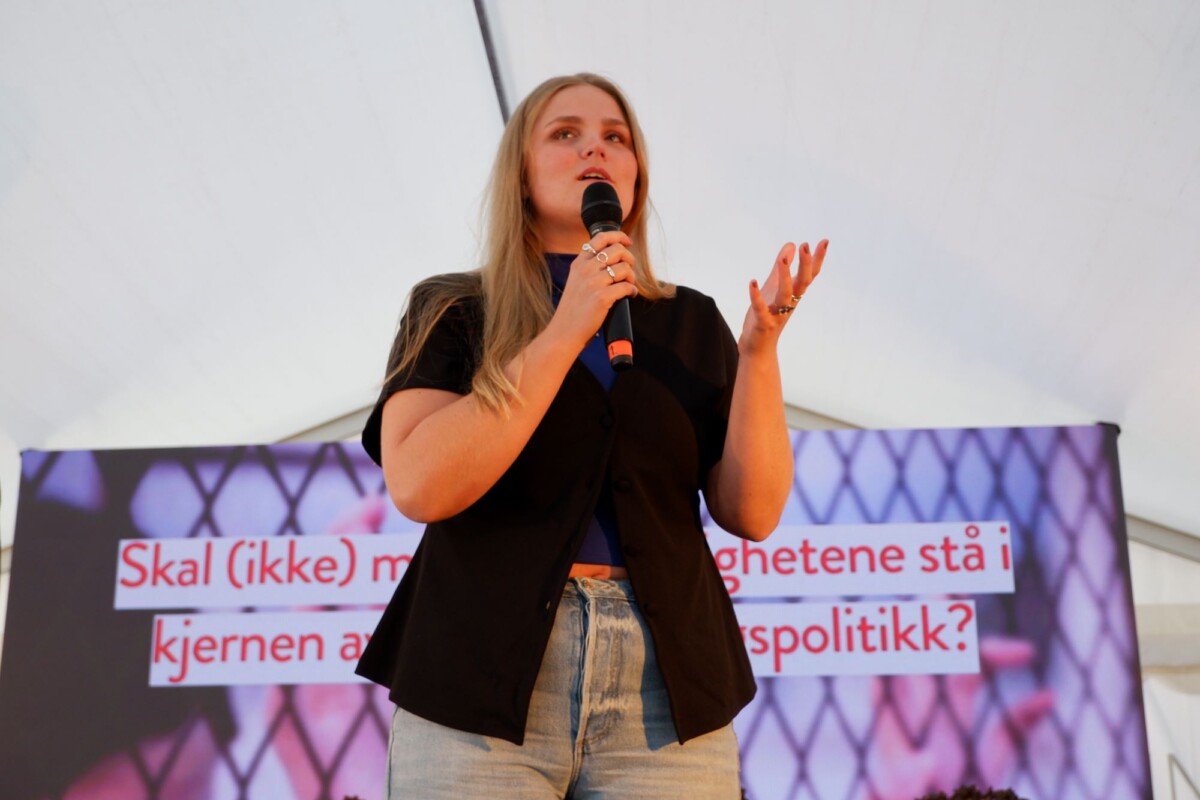 Jente pratar i mikrofon på scene